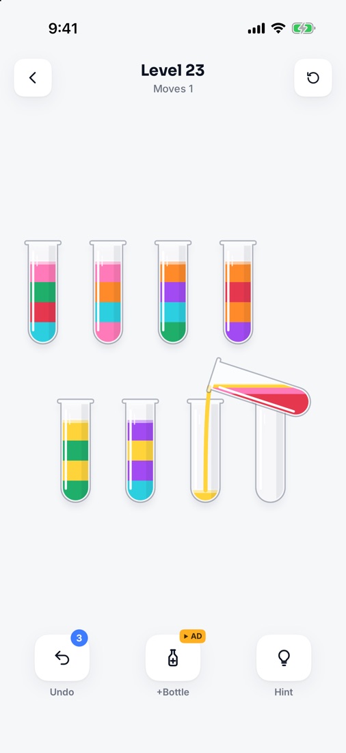 A Tint Lab level mid-pour: a tube tilts and pours pink into another, eight tubes of mixed colours around it